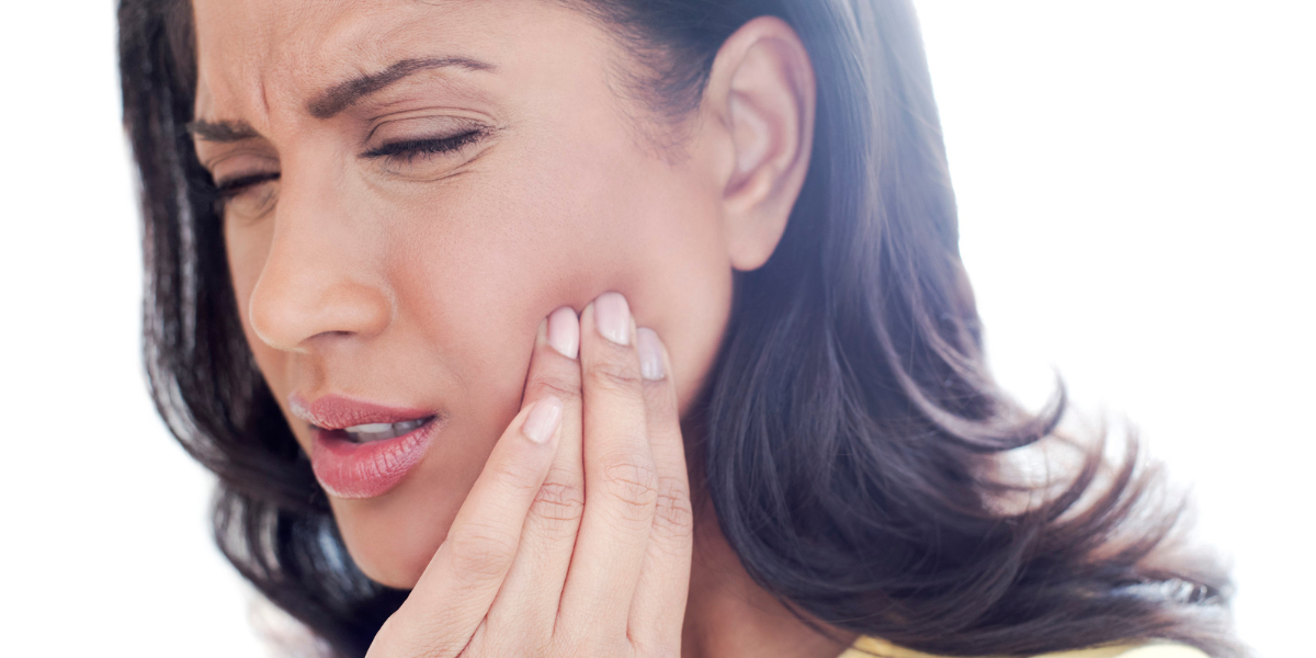 Woman holding her jaw in pain, showing the urgent need for a 24 hour emergency dentist