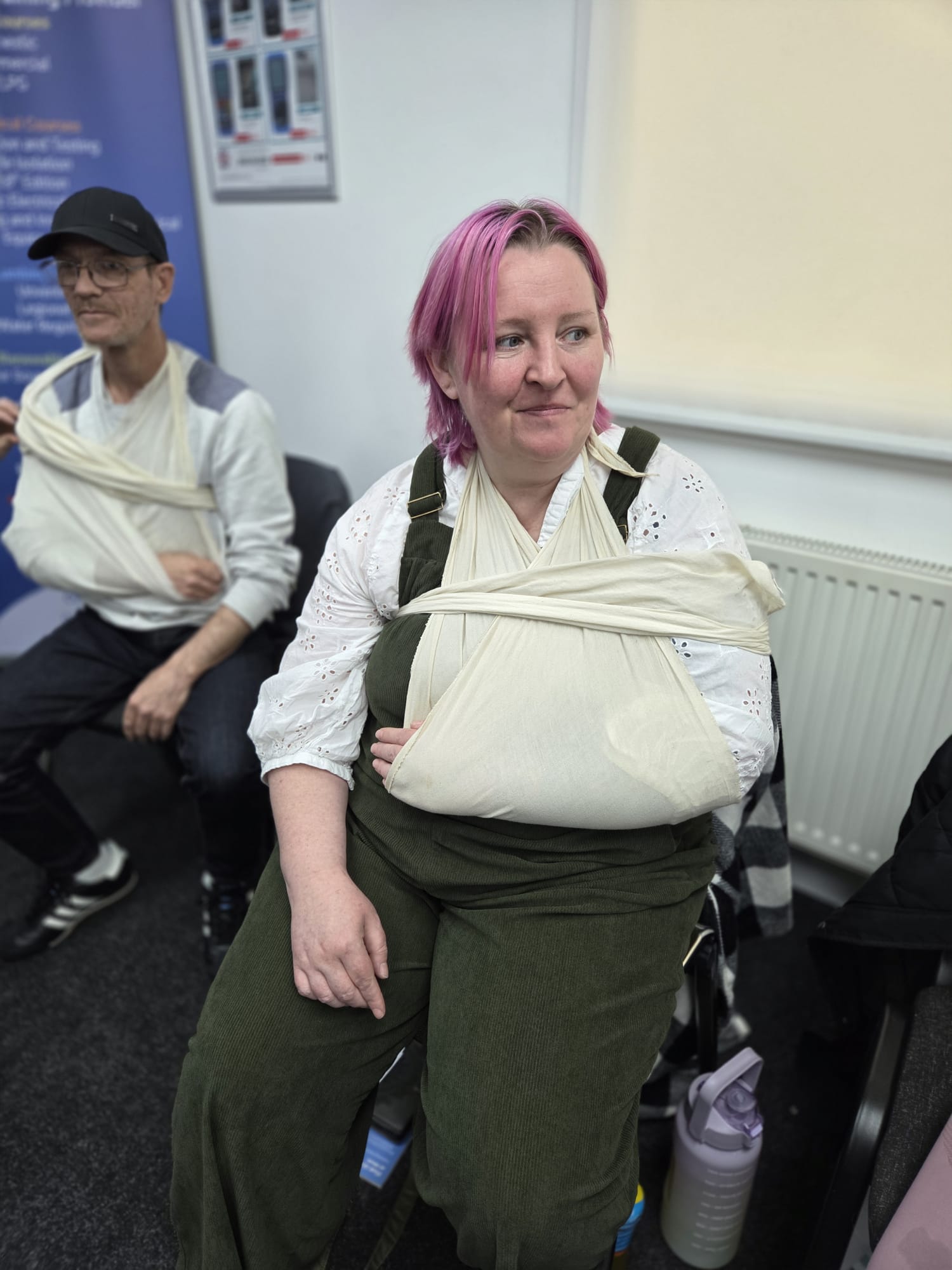 Course delegates wearing triangular-bandage arm slings during first aid training