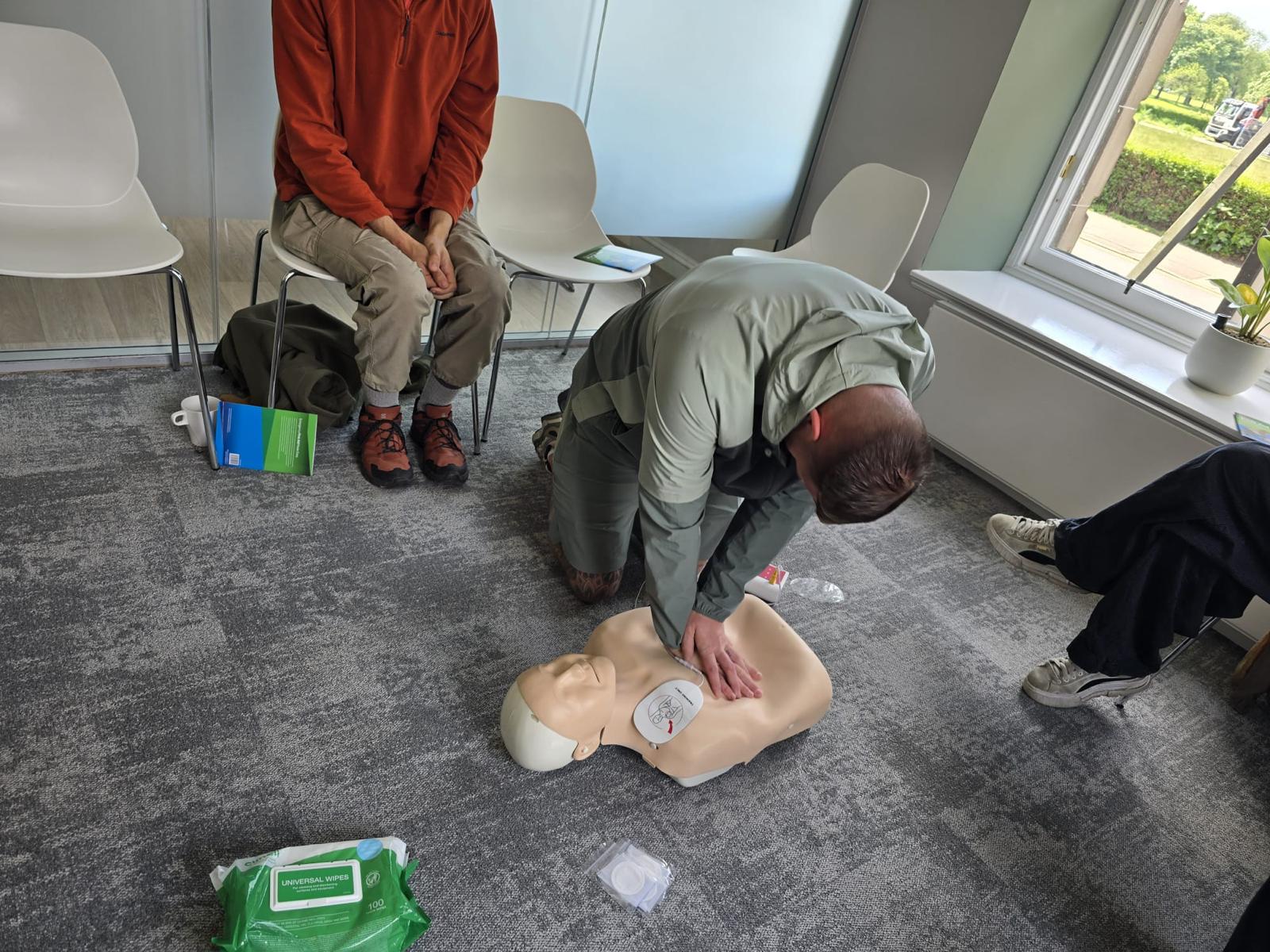 A delegate practising CPR and AED use on a training manikin