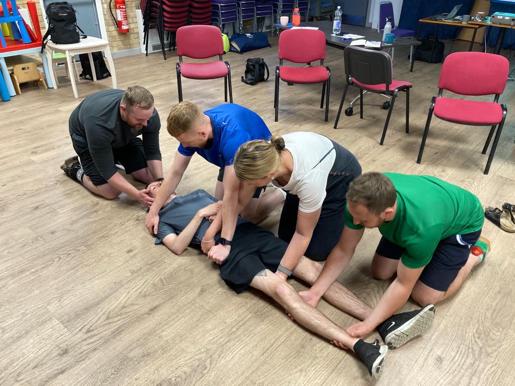 First aid course delegates practising casualty handling in Leeds