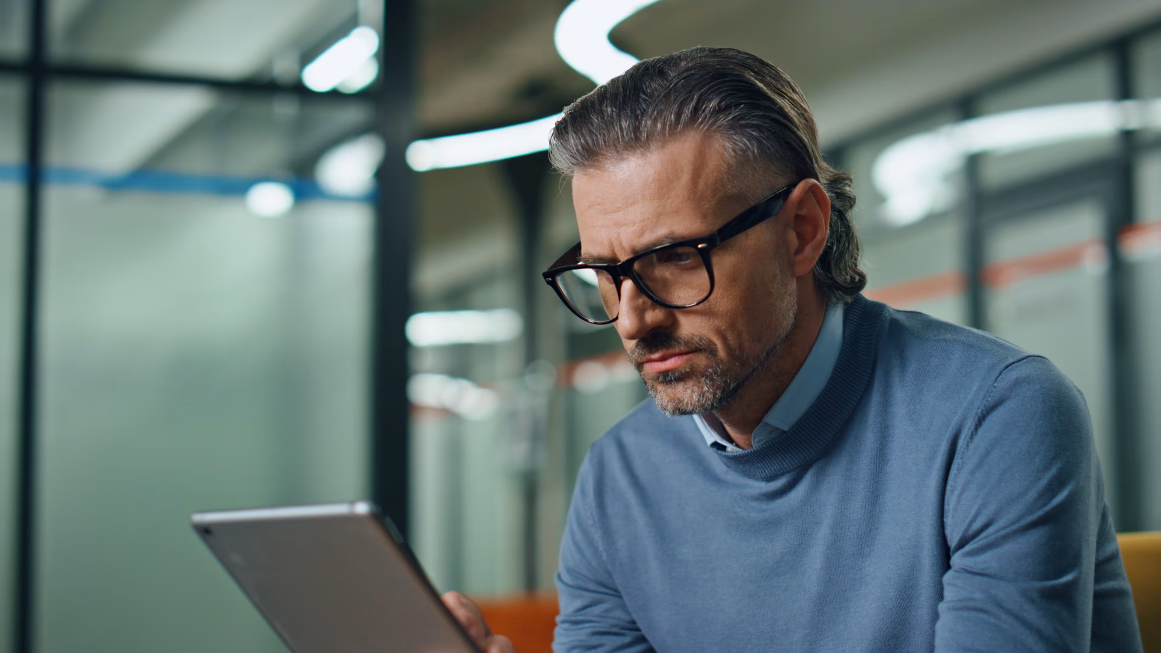 Manager bei Lean Sherpas vertieft im Strategieprozess mit Tablet – Fokus auf Organisationsdesign.
