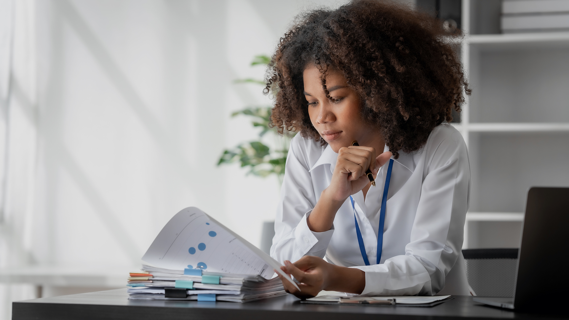 A mature male business owner reviewing paperwork while sitting at desk in an office