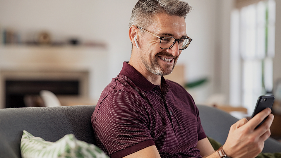 A mature male business owner reviewing paperwork while sitting at desk in an office
