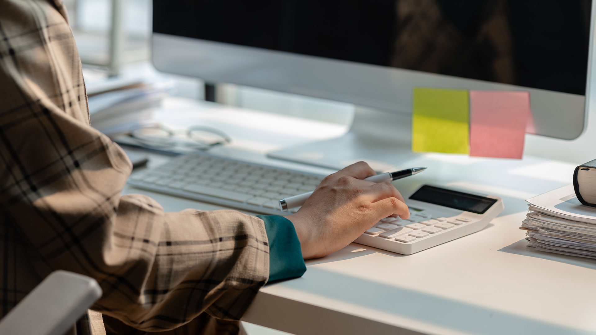 A mature male business owner reviewing paperwork while sitting at desk in an office