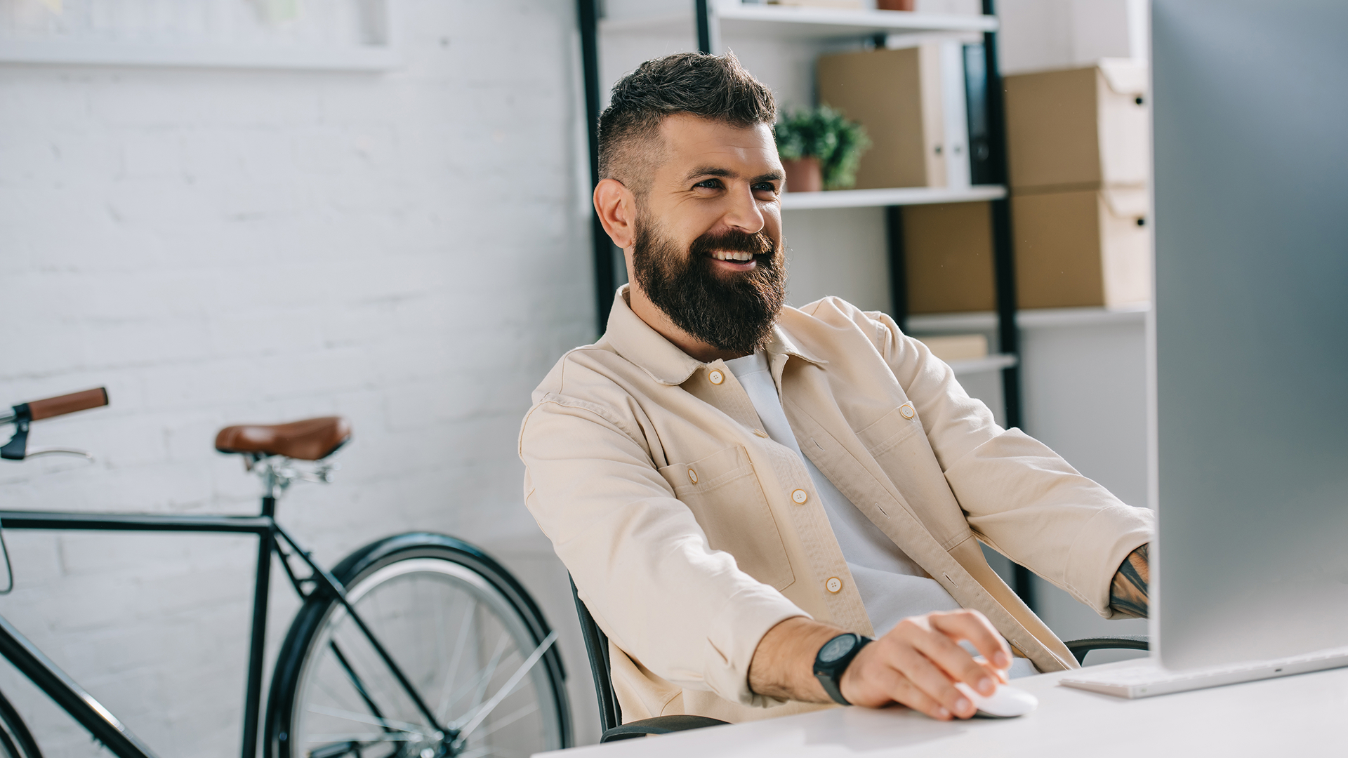 A mature male business owner reviewing paperwork while sitting at desk in an office