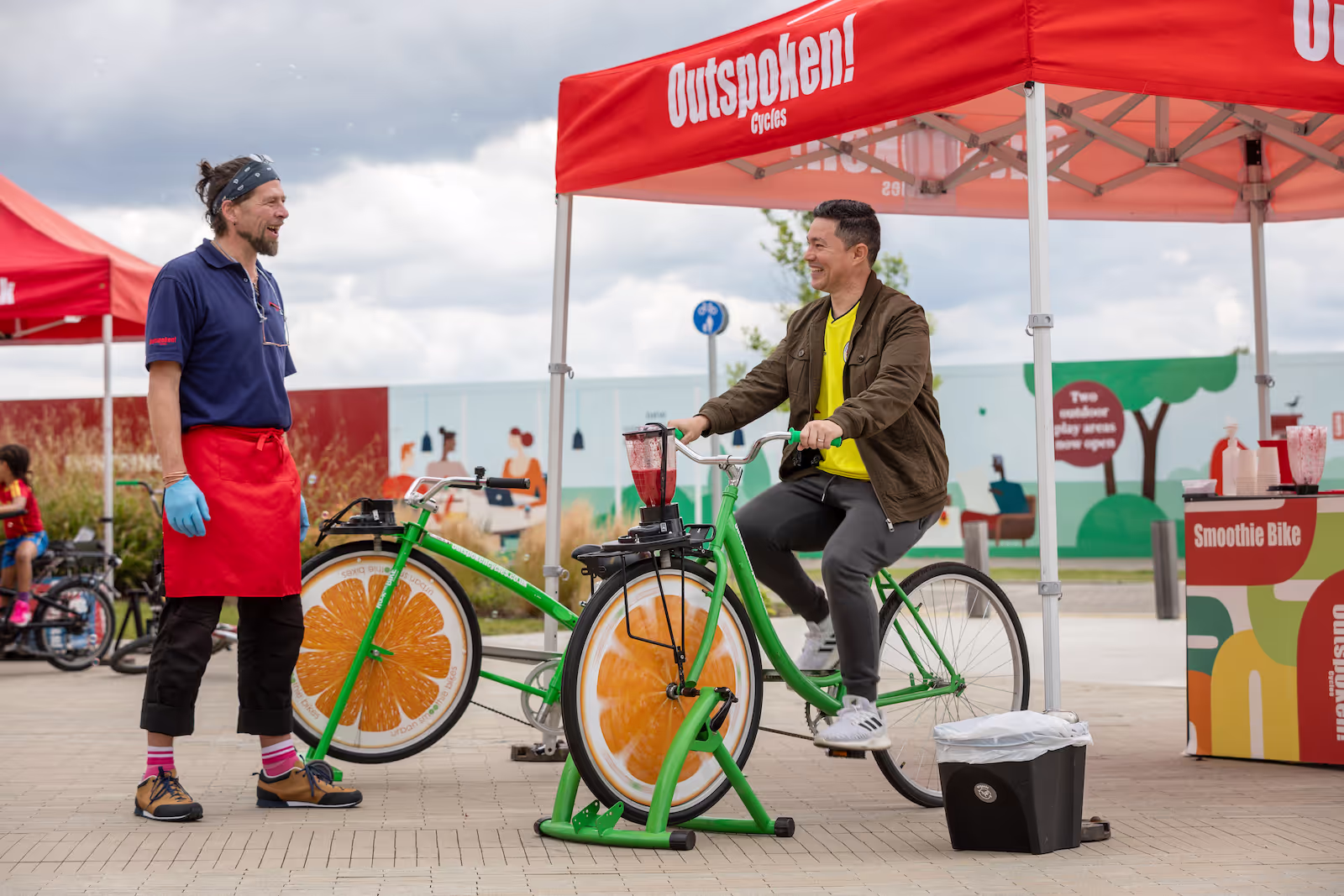 A man cycles on a stationary bike to power a juice blender as part of a sustainable travel promotion