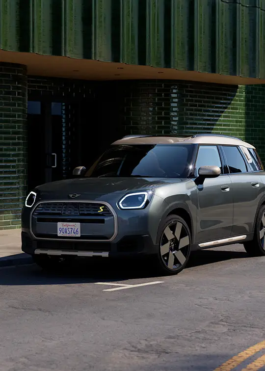 MINI Countryman E in Grau vor moderner Fassade – MOTORHEIMAT Wagner-Schwarz in Kirchseeon, Traunstein, Altenmarkt, Wasserburg und Oberhaching