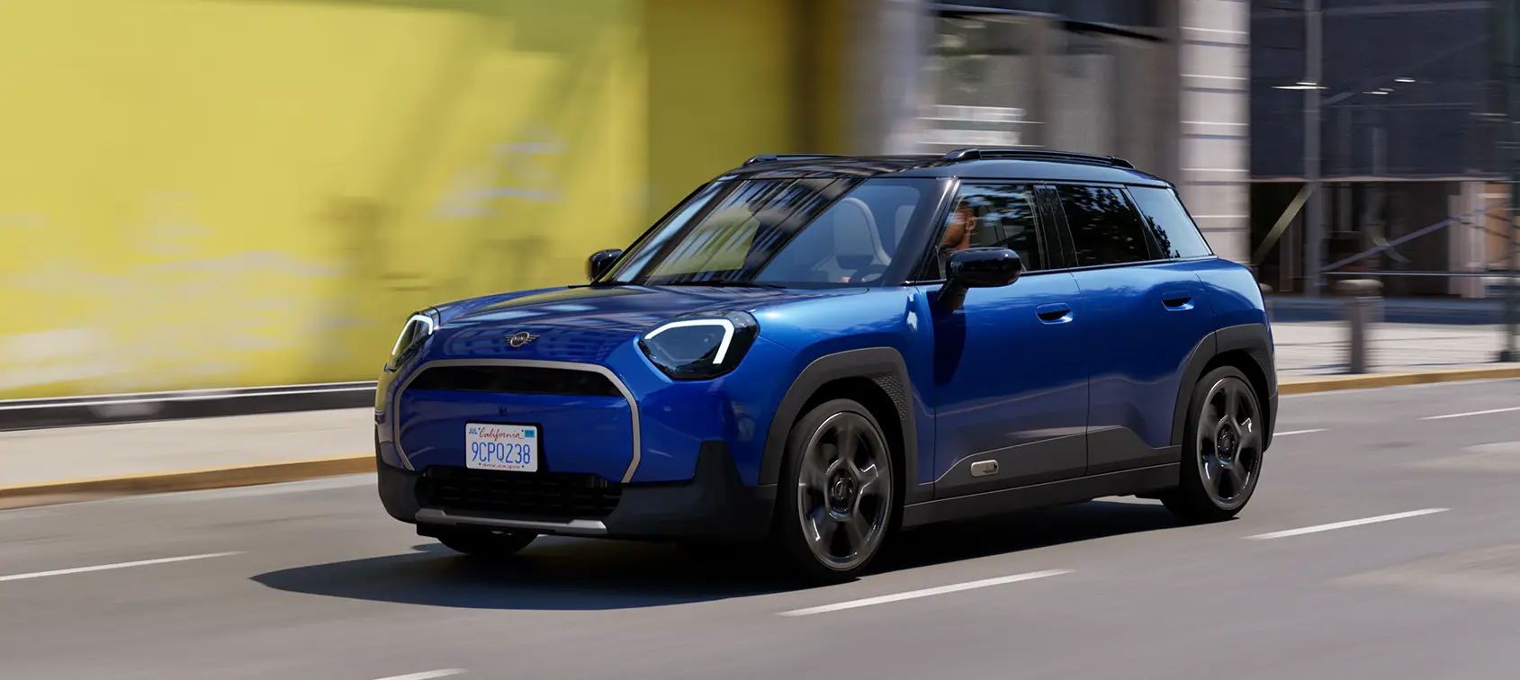MINI Aceman E in Blau fährt durch die Stadt – MOTORHEIMAT Wagner-Schwarz in Kirchseeon, Traunstein, Altenmarkt, Wasserburg und Oberhaching