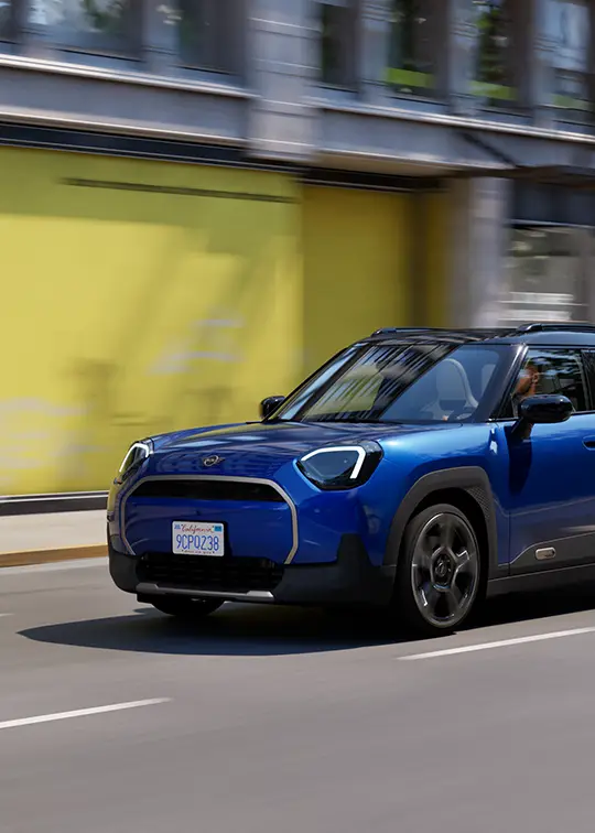 MINI Aceman E in Blau fährt durch die Stadt – MOTORHEIMAT Wagner-Schwarz in Kirchseeon, Traunstein, Altenmarkt, Wasserburg und Oberhaching