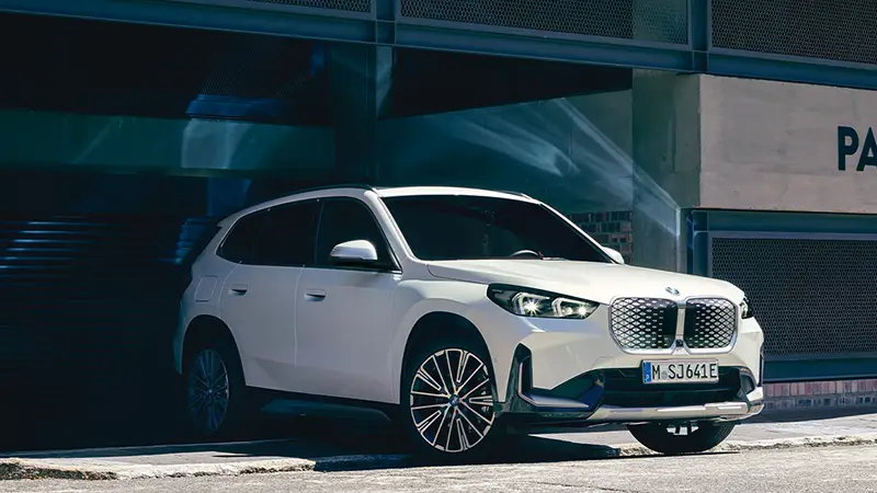 Weißer BMW iX1 SUV in urbaner Umgebung – MOTORHEIMAT WAGNER-SCHWARZ in Kirchseeon, Traunstein, Altenmarkt, Wasserburg und Oberhaching