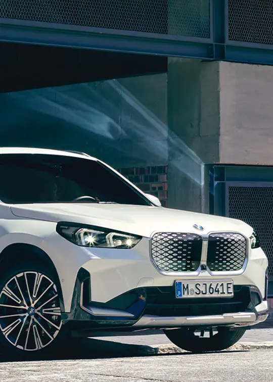 Weißer BMW iX1 SUV in urbaner Umgebung – MOTORHEIMAT WAGNER-SCHWARZ in Kirchseeon, Traunstein, Altenmarkt, Wasserburg und Oberhaching