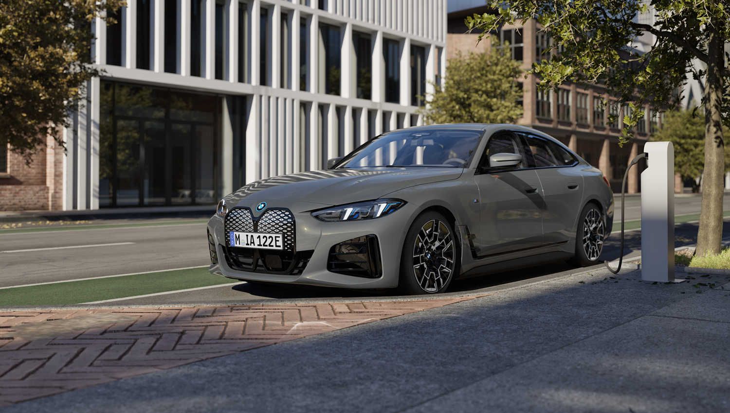 Grauer BMW i4 steht an der Ladesäule vor modernem Hintergrund – MOTORHEIMAT Wagner-Schwarz in Kirchseeon, Traunstein, Altenmarkt, Wasserburg und Oberhaching