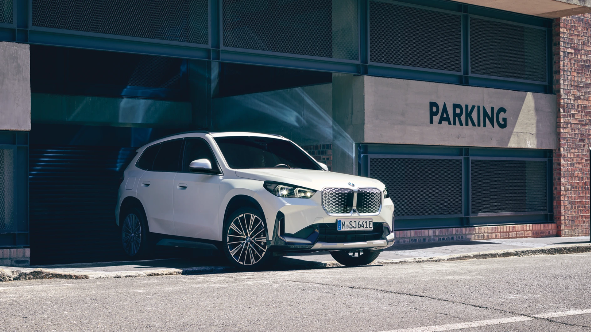 Weißer BMW iX1 SUV in urbaner Umgebung – MOTORHEIMAT WAGNER-SCHWARZ in Kirchseeon, Traunstein, Altenmarkt, Wasserburg und Oberhaching