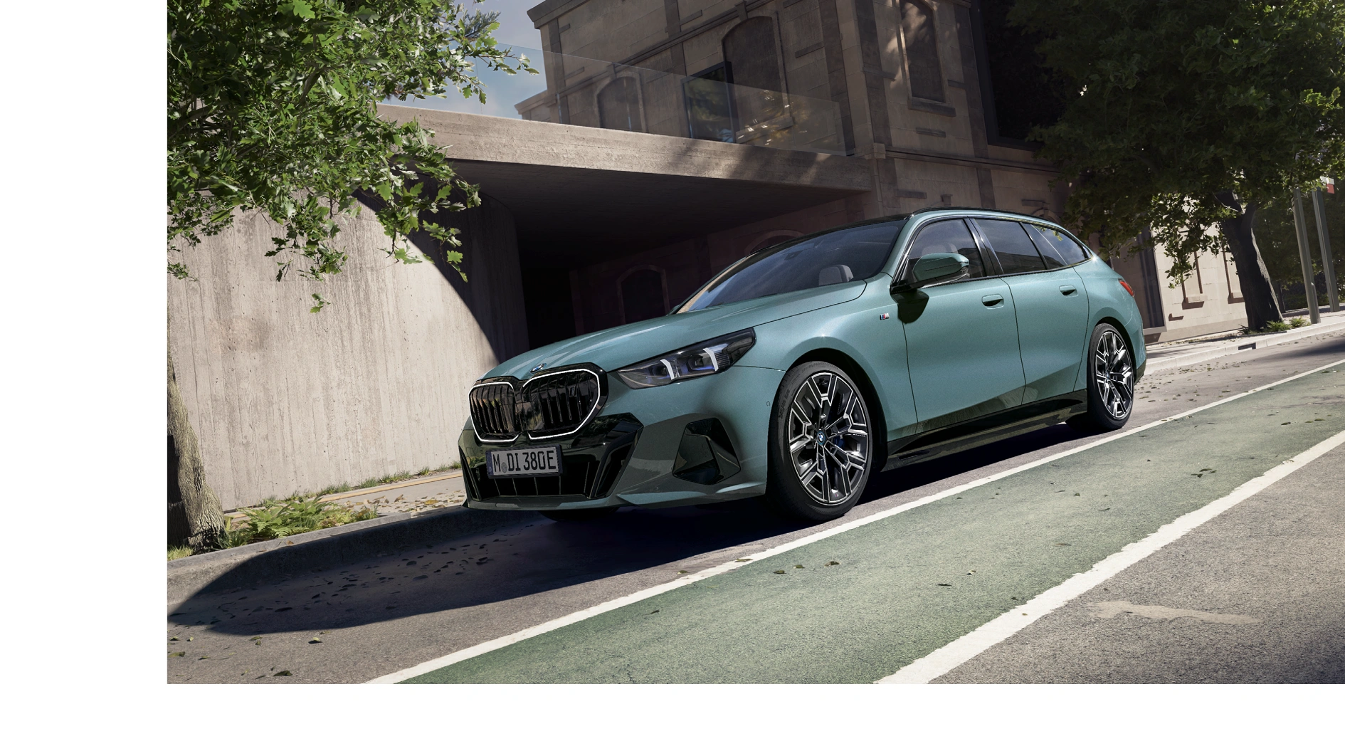 Grüner BMW 5er Touring Plug-in-Hybrid mit sportlicher M-Ausstattung parkt vor moderner Wand – MOTORHEIMAT Wagner-Schwarz in Kirchseeon, Traunstein, Altenmarkt, Wasserburg und Oberhaching