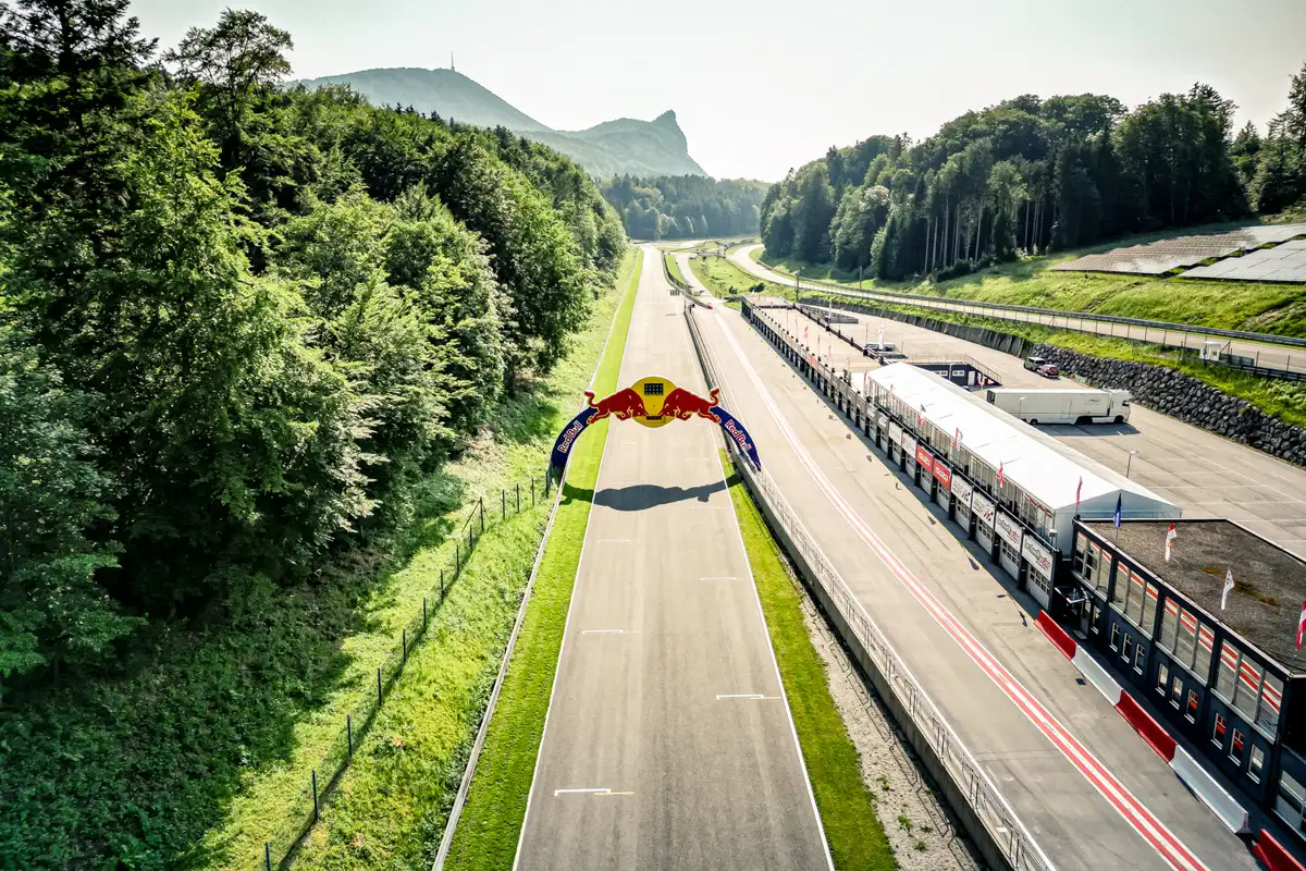 Start Zielgerade auf dem Salzburgring. Rennstrecke mit Bergen und Wald im Hintergrund