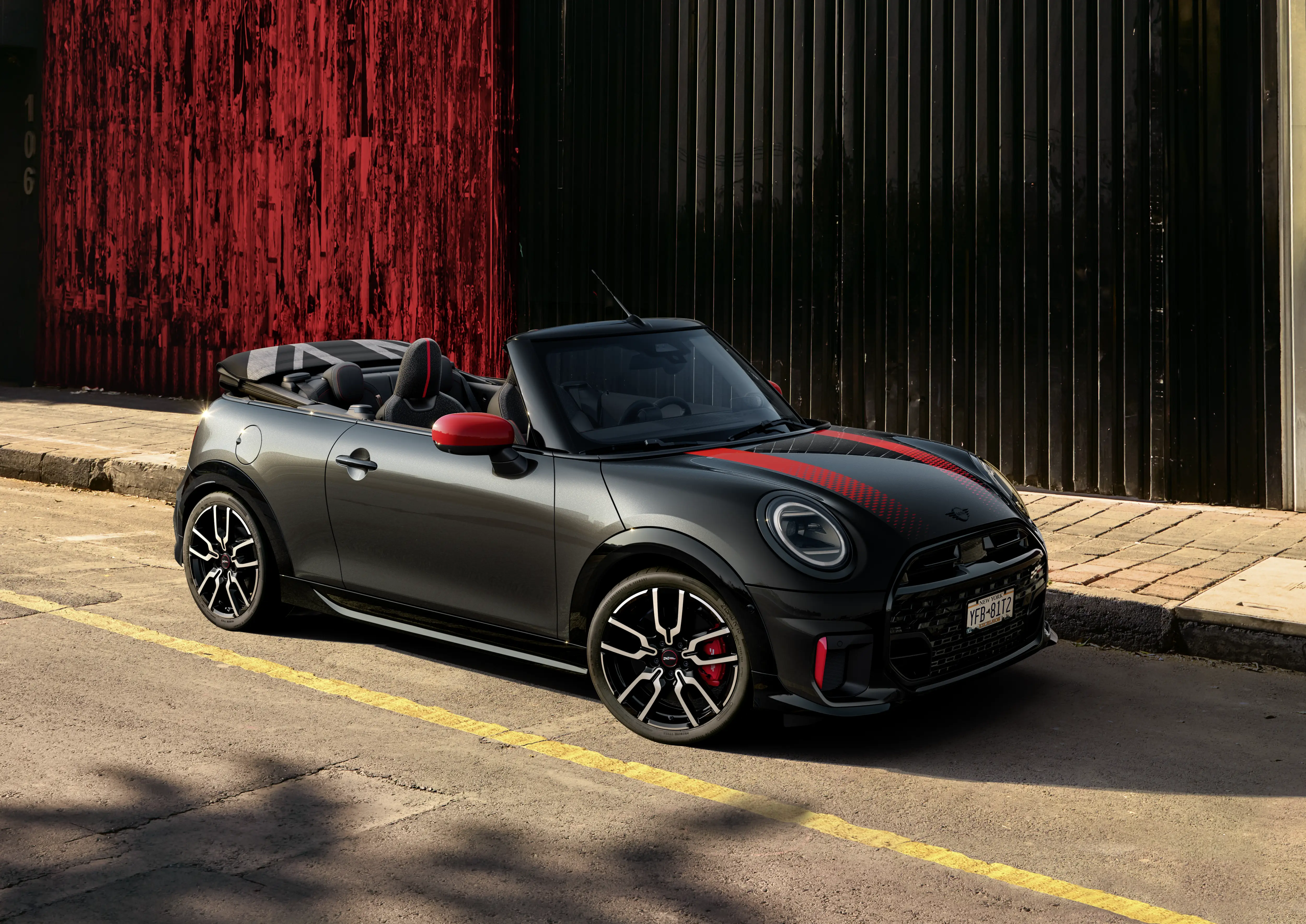 Schwarzer MINI JCW Cabrio fährt dynamisch durch die Stadt – MOTORHEIMAT Wagner-Schwarz in Kirchseeon, Traunstein, Altenmarkt, Wasserburg und Oberhaching