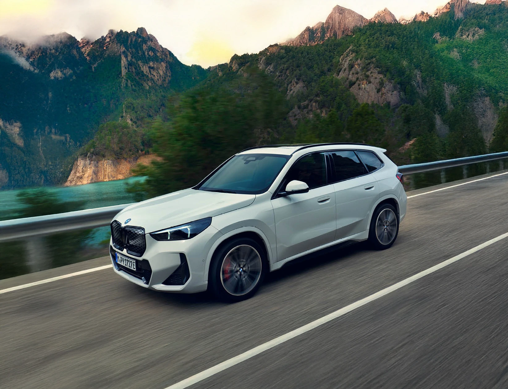 Weißer BMW iX1 SUV fährt dynamisch auf einer Landstraße – MOTORHEIMAT WAGNER-SCHWARZ in Kirchseeon, Traunstein, Altenmarkt, Wasserburg und Oberhaching