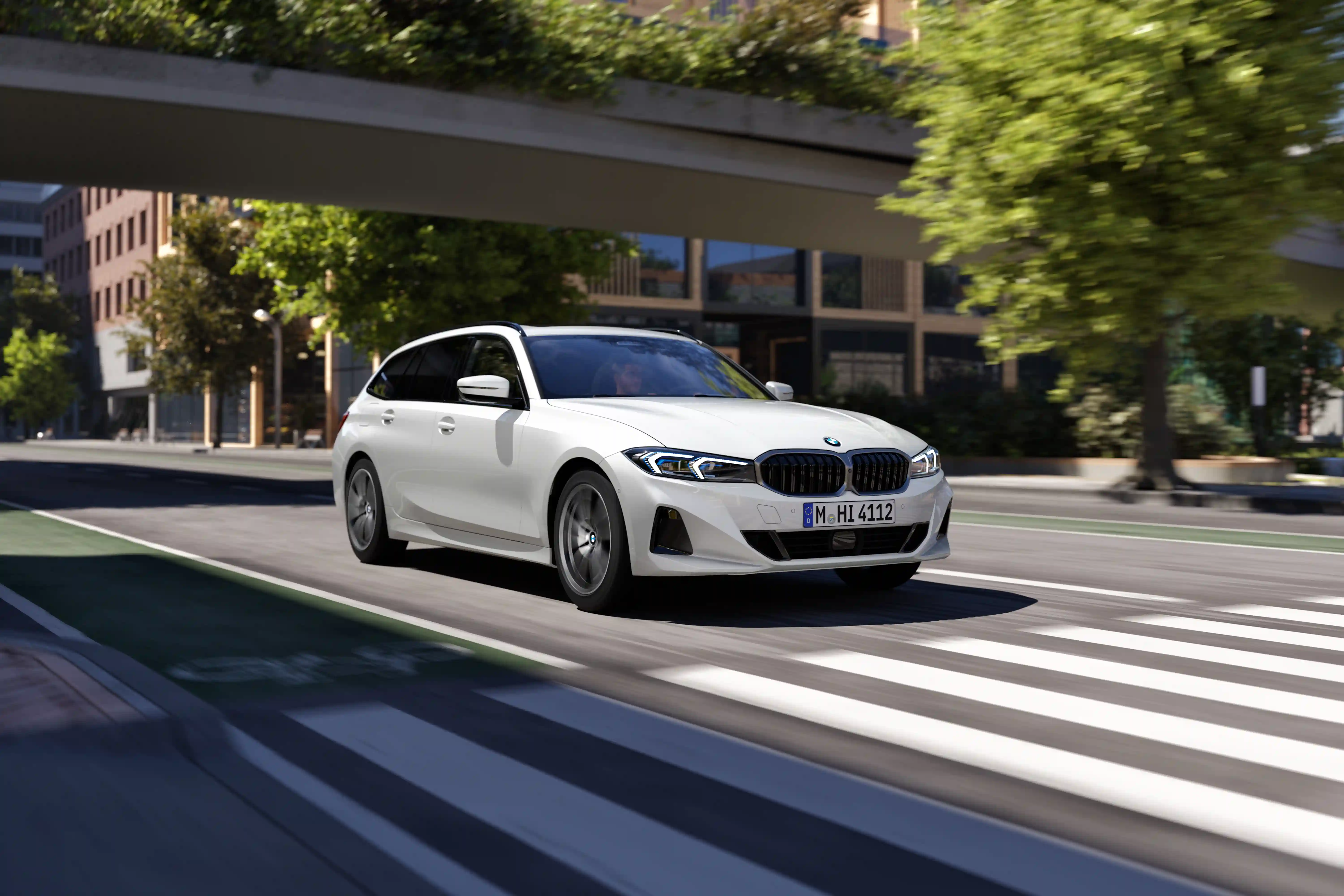 Blauer BMW 3er Touring fährt dynamisch auf der Straße in einer Innenstadt – MOTORHEIMAT Wagner-Schwarz in Kirchseeon, Traunstein, Altenmarkt, Wasserburg und Oberhaching