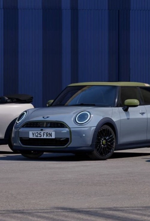 MINI Cooper E Paul Smith Edition steht elegant geparkt vor einer blauen Wand – MOTORHEIMAT Wagner-Schwarz in Kirchseeon, Traunstein, Altenmarkt, Wasserburg und Oberhaching
