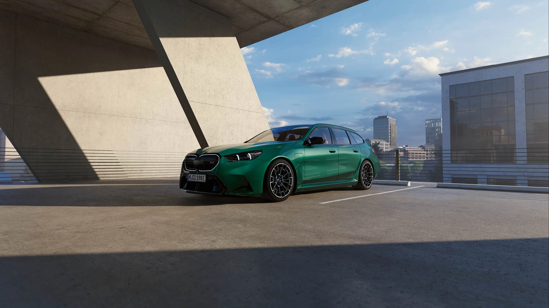 Grüner BMW M5 Touring vor einer Aussicht mit Hochhäuser – pure Fahrdynamik bei MOTORHEIMAT Wagner-Schwarz in Kirchseeon, Traunstein, Altenmarkt, Wasserburg und Oberhaching