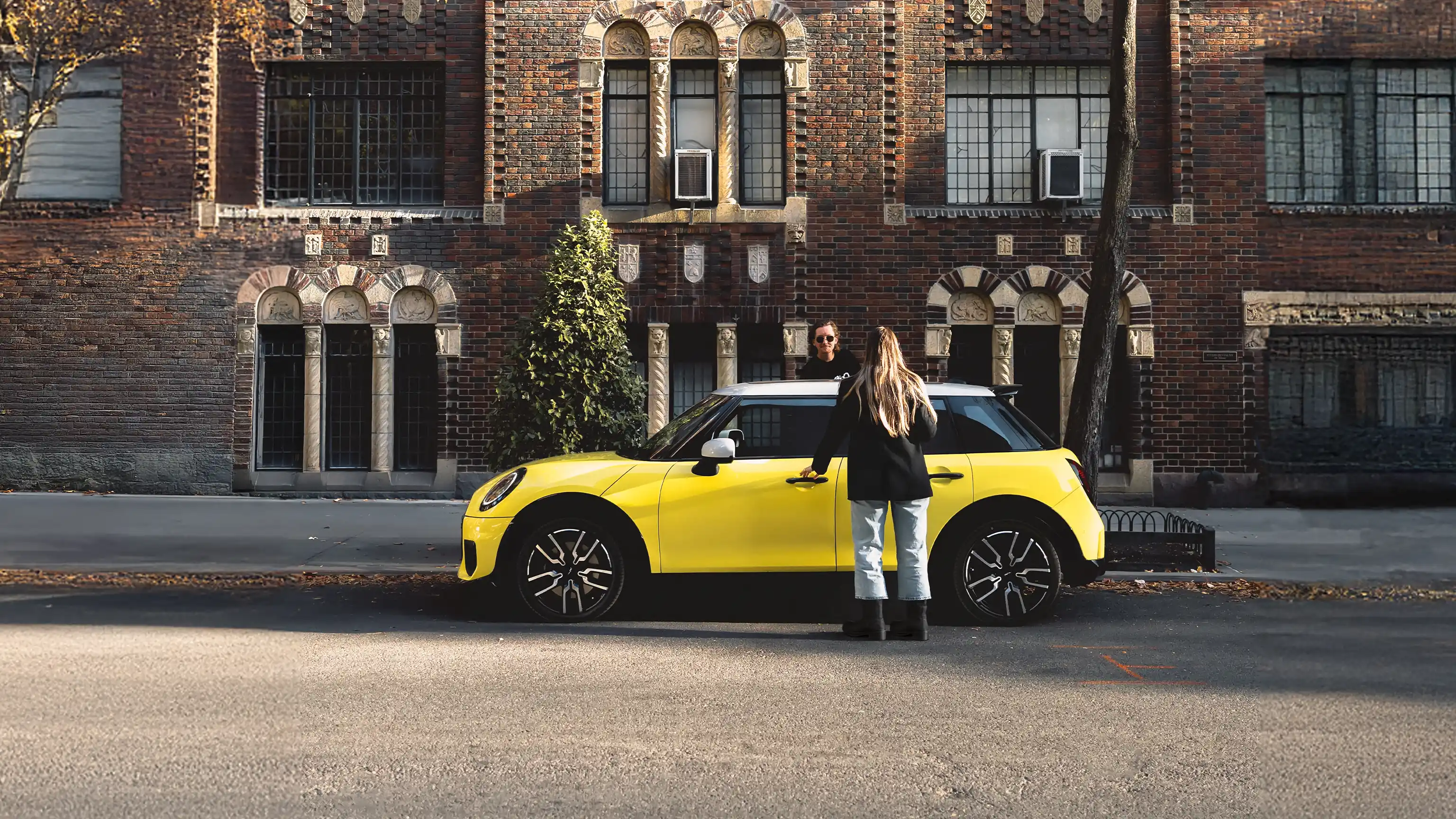 MINI Cooper C in Gelb mit schwarzem Dach vor einer historischen Backsteinfassade – MOTORHEIMAT Wagner-Schwarz in Kirchseeon, Traunstein, Altenmarkt, Wasserburg und Oberhaching