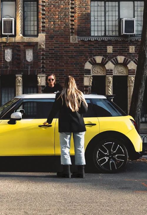 MINI Cooper C in Gelb mit schwarzem Dach vor einer historischen Backsteinfassade – MOTORHEIMAT Wagner-Schwarz in Kirchseeon, Traunstein, Altenmarkt, Wasserburg und Oberhaching