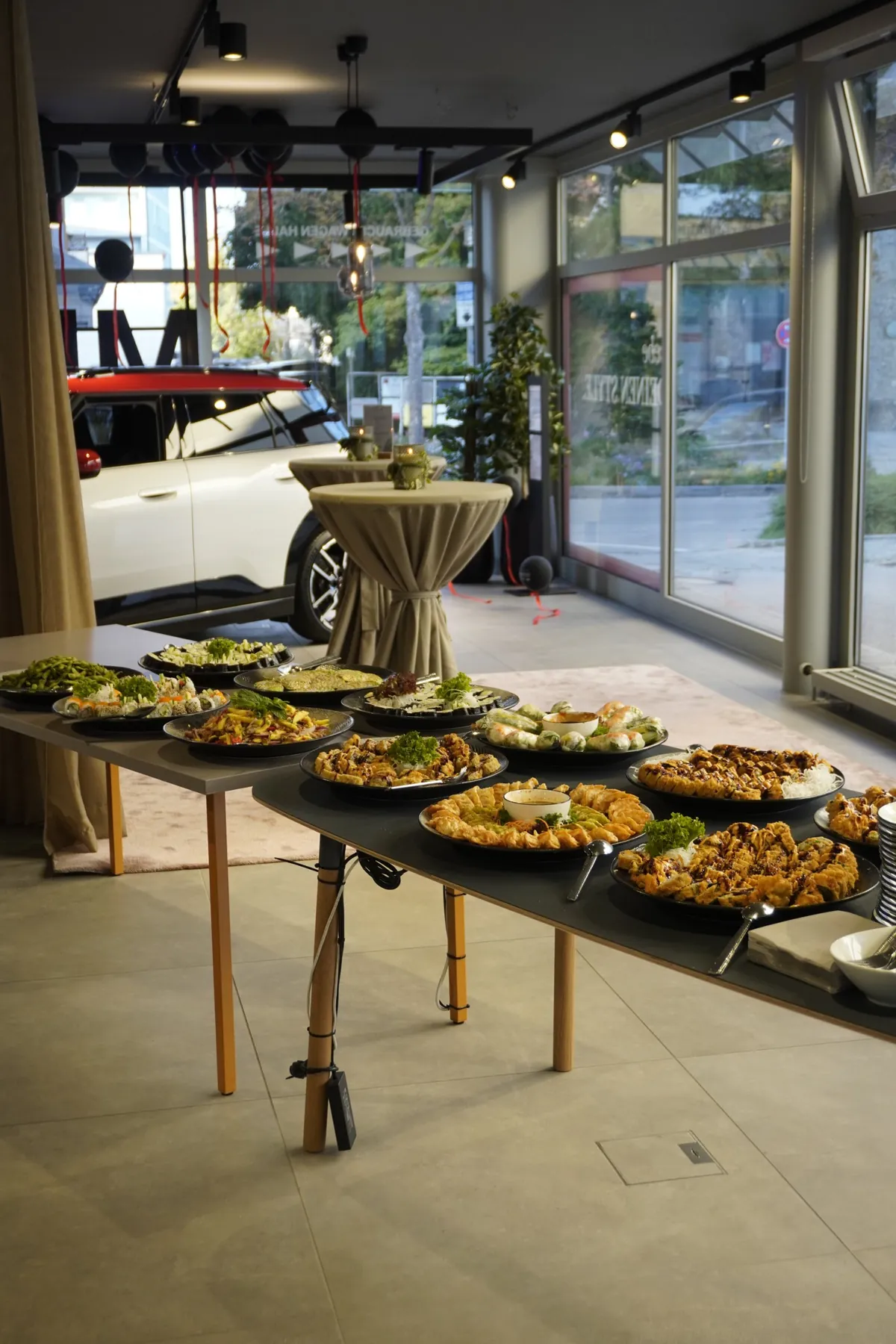 Fingerfood-Buffet beim MINI Afterwork in Traunstein, im Hintergrund ein MINI im Showroom