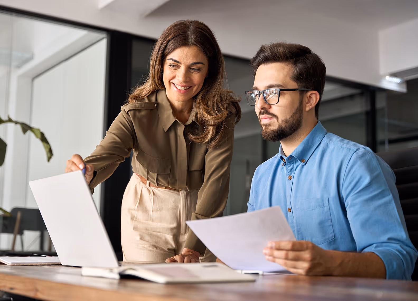 Qualitätsmanager zeigt interessiert auf QM Software.