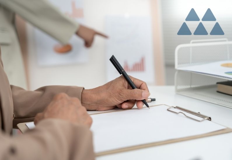 Hand with pen on clipboard