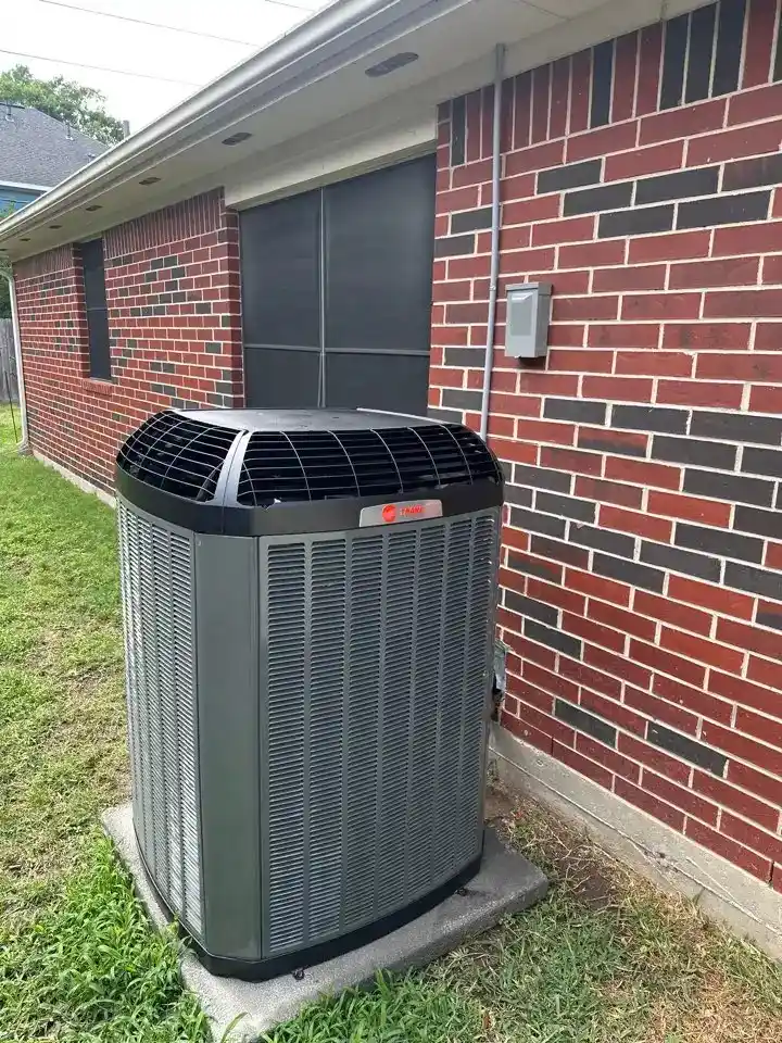 A Trane air conditioning installed in front of a residential house, showcasing energy-efficient heating and cooling technology.