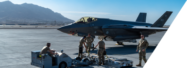 Multiple technicians collaborating on maintenance of a military aircraft