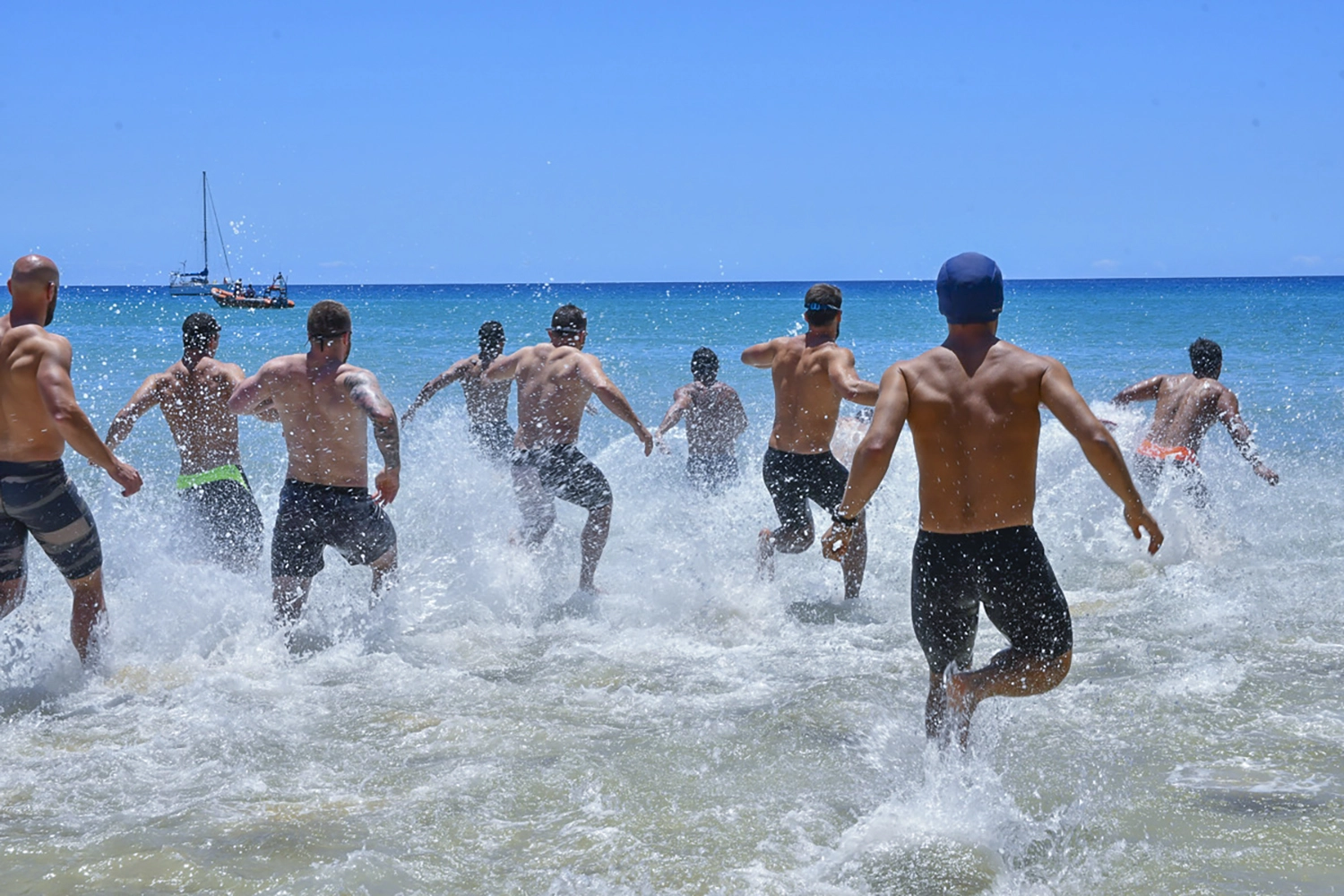 Group of men entering the sea, preparing to start the swimming workout at Madeira Games.