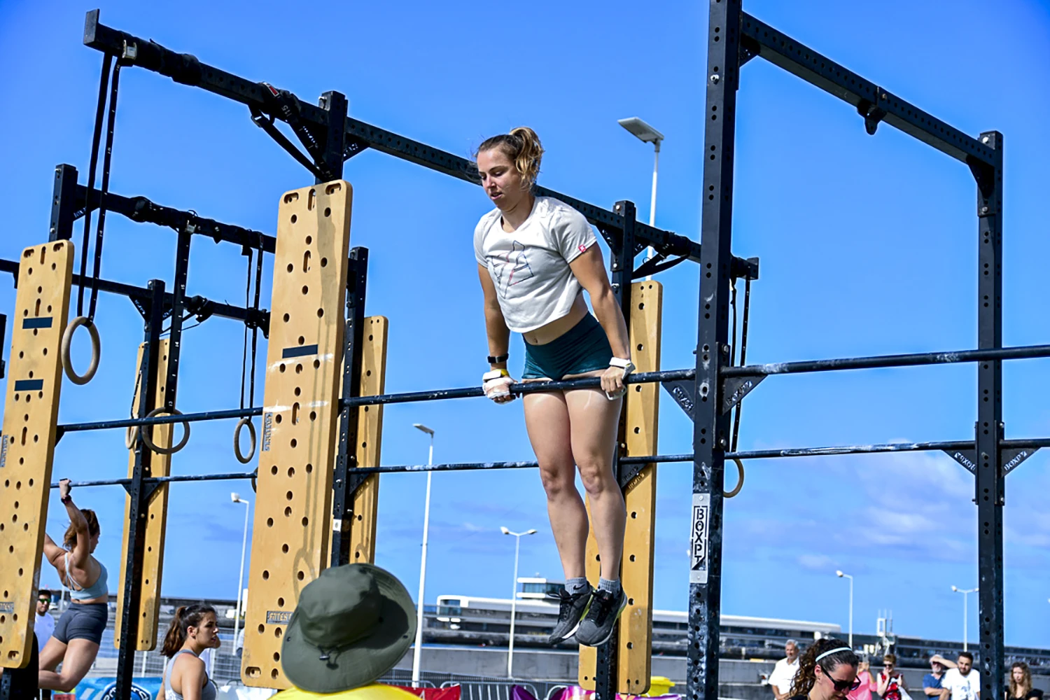 A girl doing bar muscle up at Madeira Games CrossFit event.