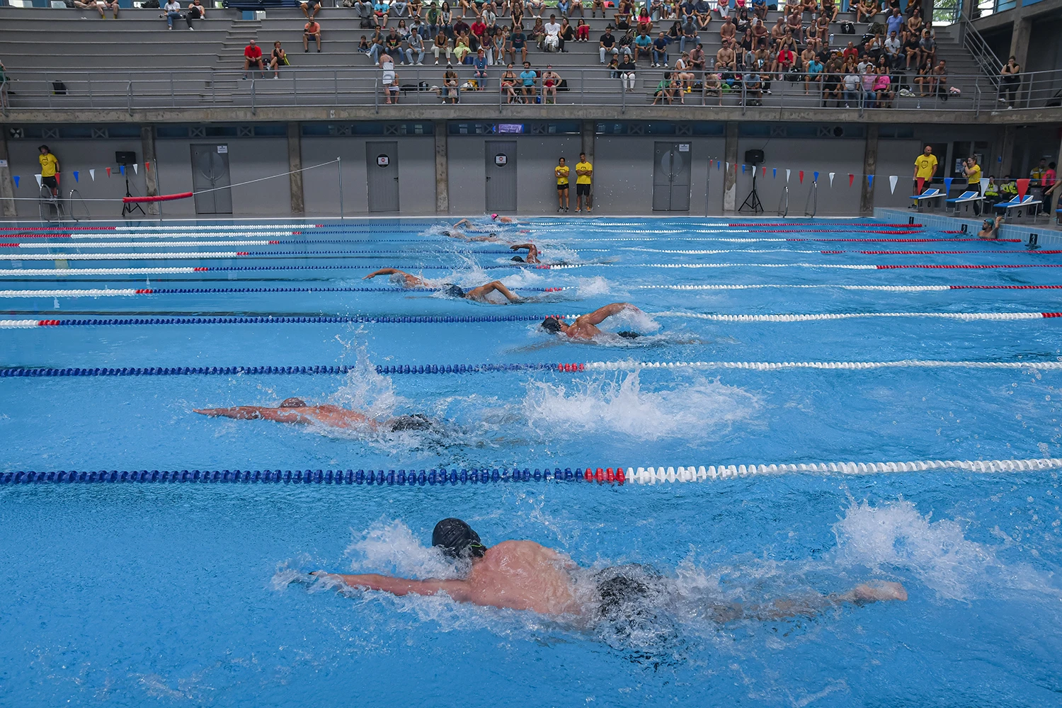 Men swimming in a pool at Madeira Games CrossFit event.