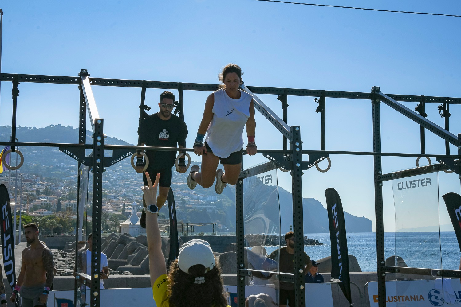 Mixed pair (male and female) performing Bar Muscle-Ups during Madeira Games 2025 Doubles event.