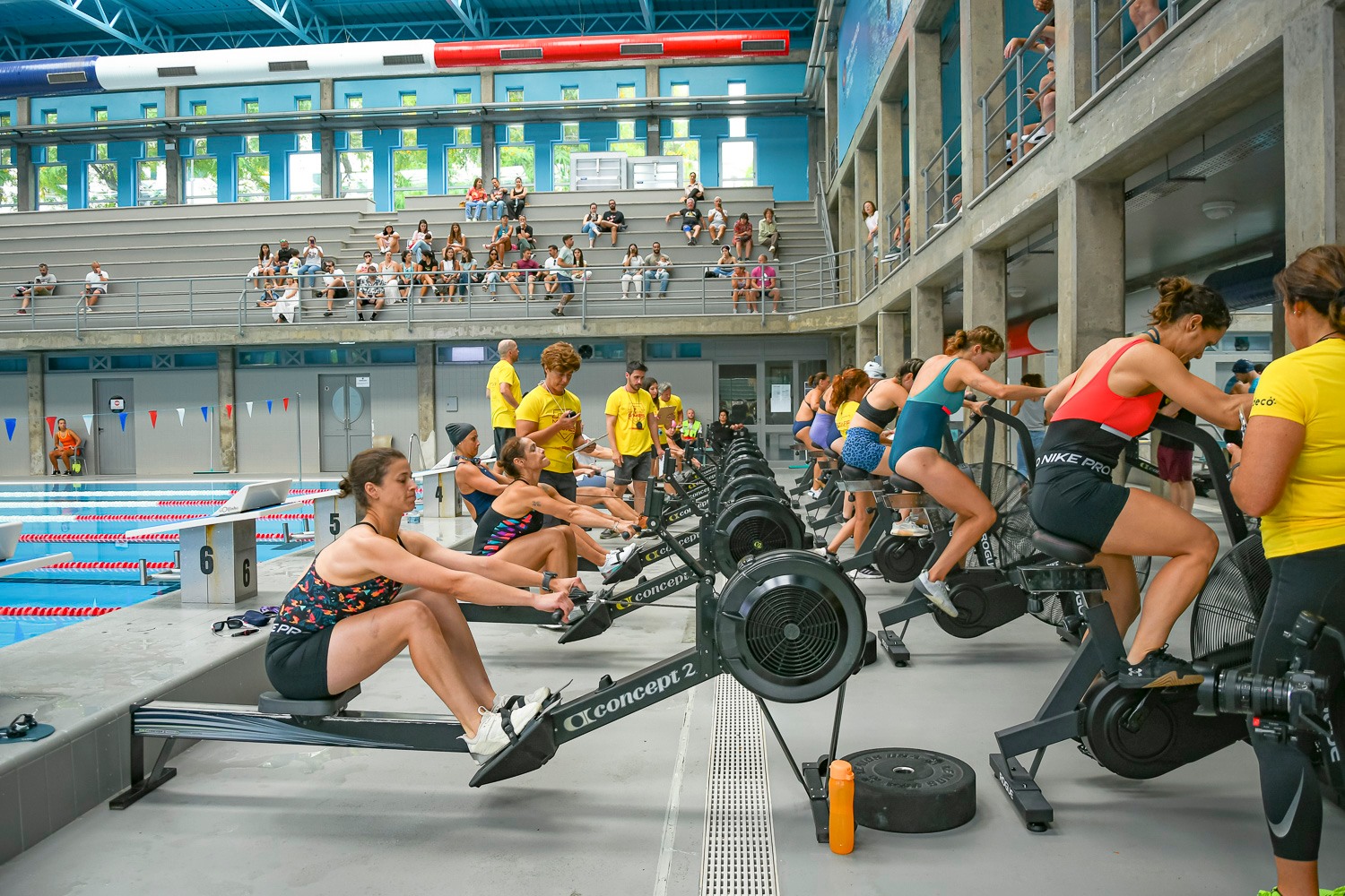 Female doubles teams pushing through an Assault Bike and Row workout during Madeira Games 2025.