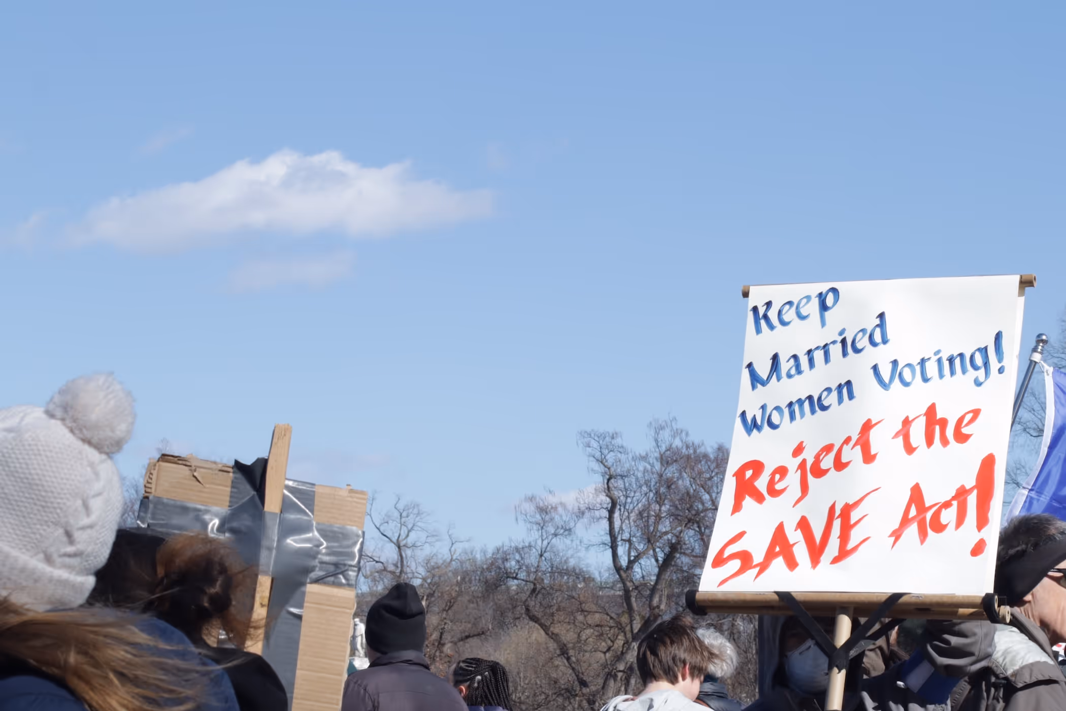 Gathering with close-up of sign "Keep Married Women Voting! Reject the SAVE Act"