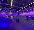 Eine Rennbahn in einer Messehalle wurde durch Lichttower illuminiert für eine Fernsehsendung