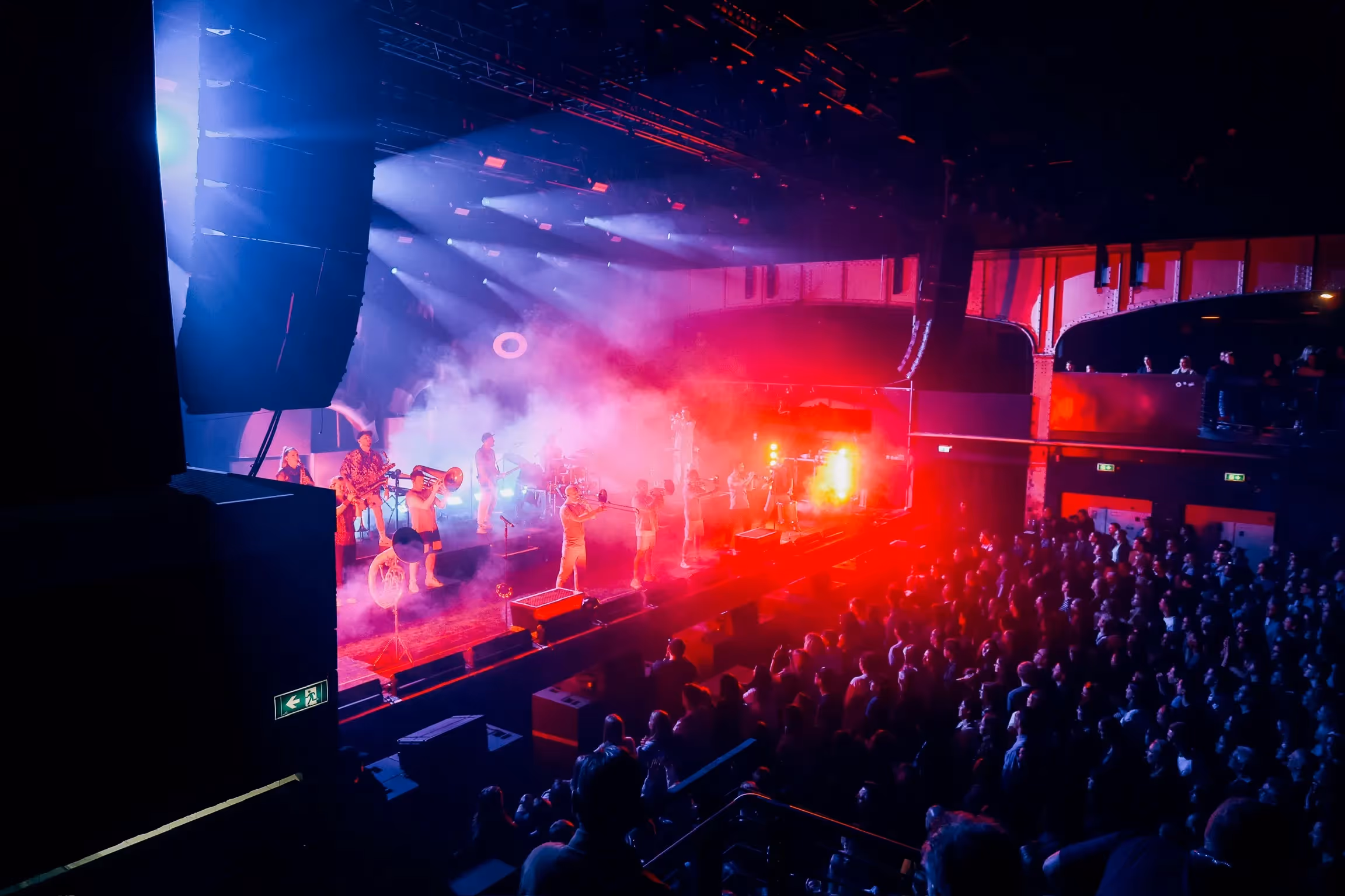 Ein foto aus der Perspektive des Publikums auf die show von einer Brass Band. Das foto wurde von einer Galerie aufgenommen