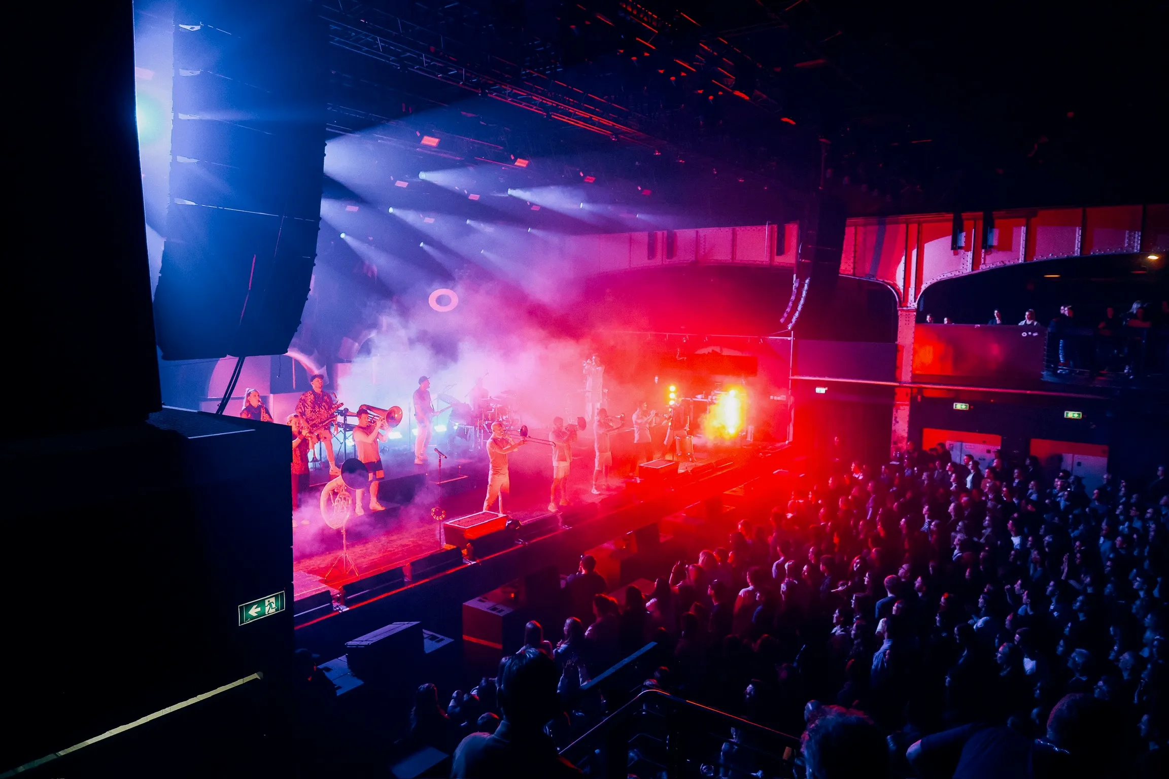 Ein foto aus der Perspektive des Publikums auf die show von einer Brass Band. Das foto wurde von einer Galerie aufgenommen