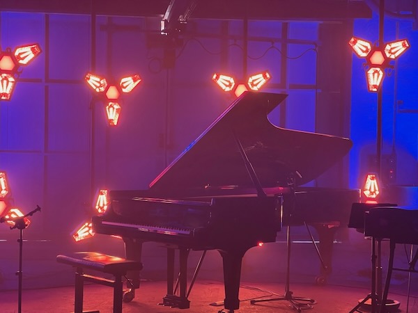 Ein Flügel steht im Vordergrund und wird von hinten mit Lichttechnik mit LED Technologie stimmungsvoll angeleuchtet