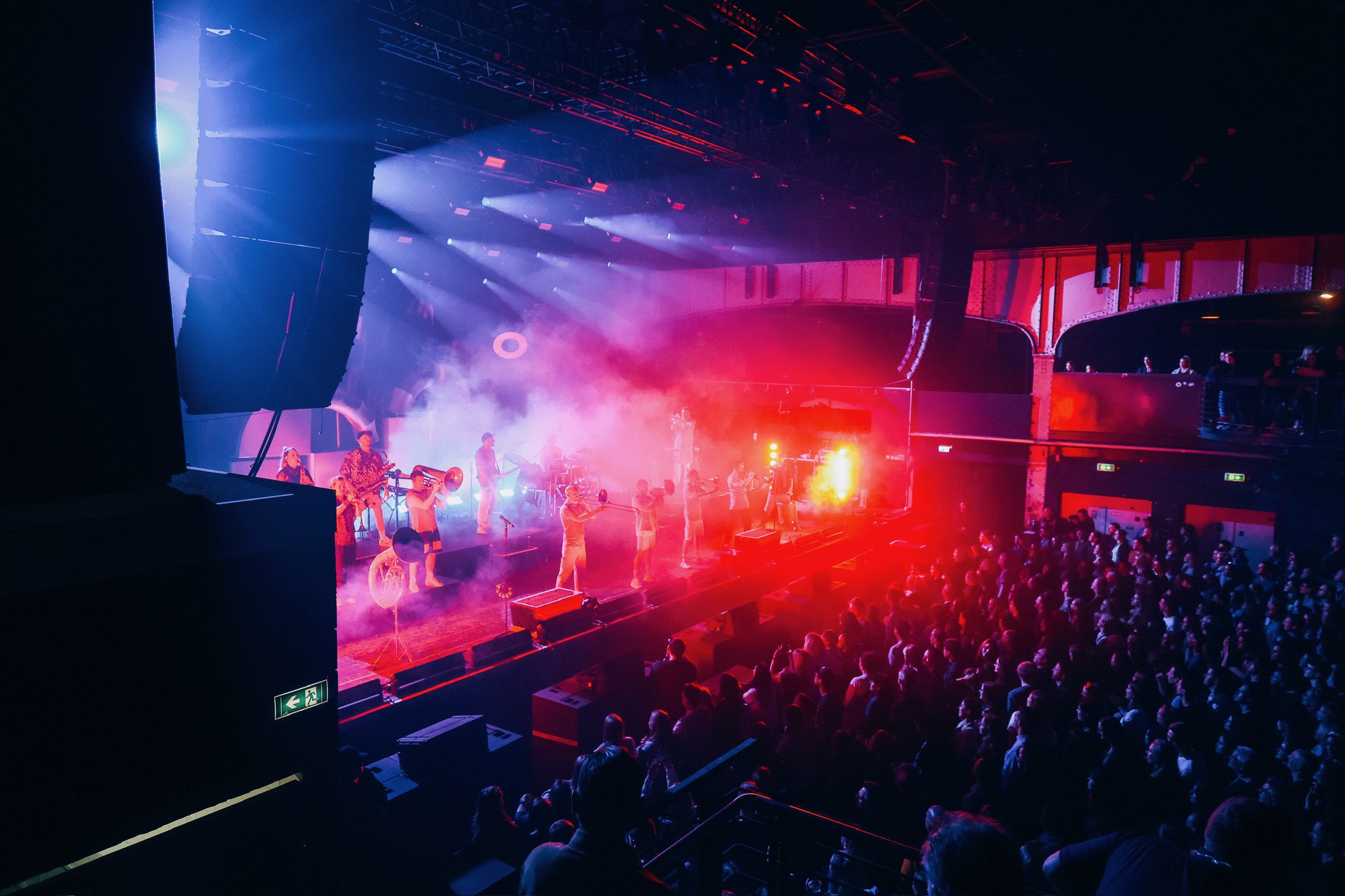 Ein foto aus der Perspektive des Publikums auf die show von einer Brass Band. Das foto wurde von einer Galerie aufgenommen