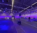 Eine Rennbahn in einer Messehalle wurde durch Lichttower illuminiert für eine Fernsehsendung