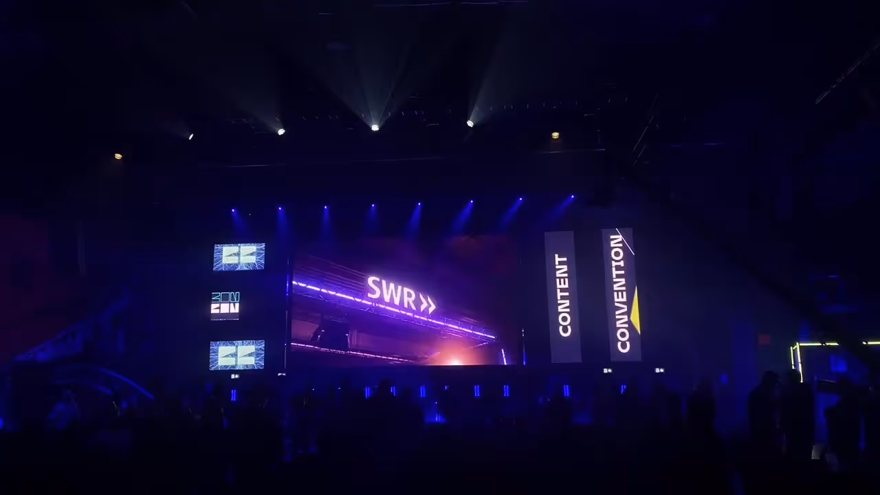 Conference hall with illuminated stage and screens – conference technology by photon