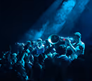 Brass band playing in blue stage lighting – staging and sound technology for festivals by photon