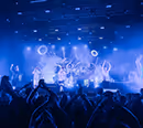 Band playing in blue stage lighting in front of a cheering festival crowd – stage programme technology by photon