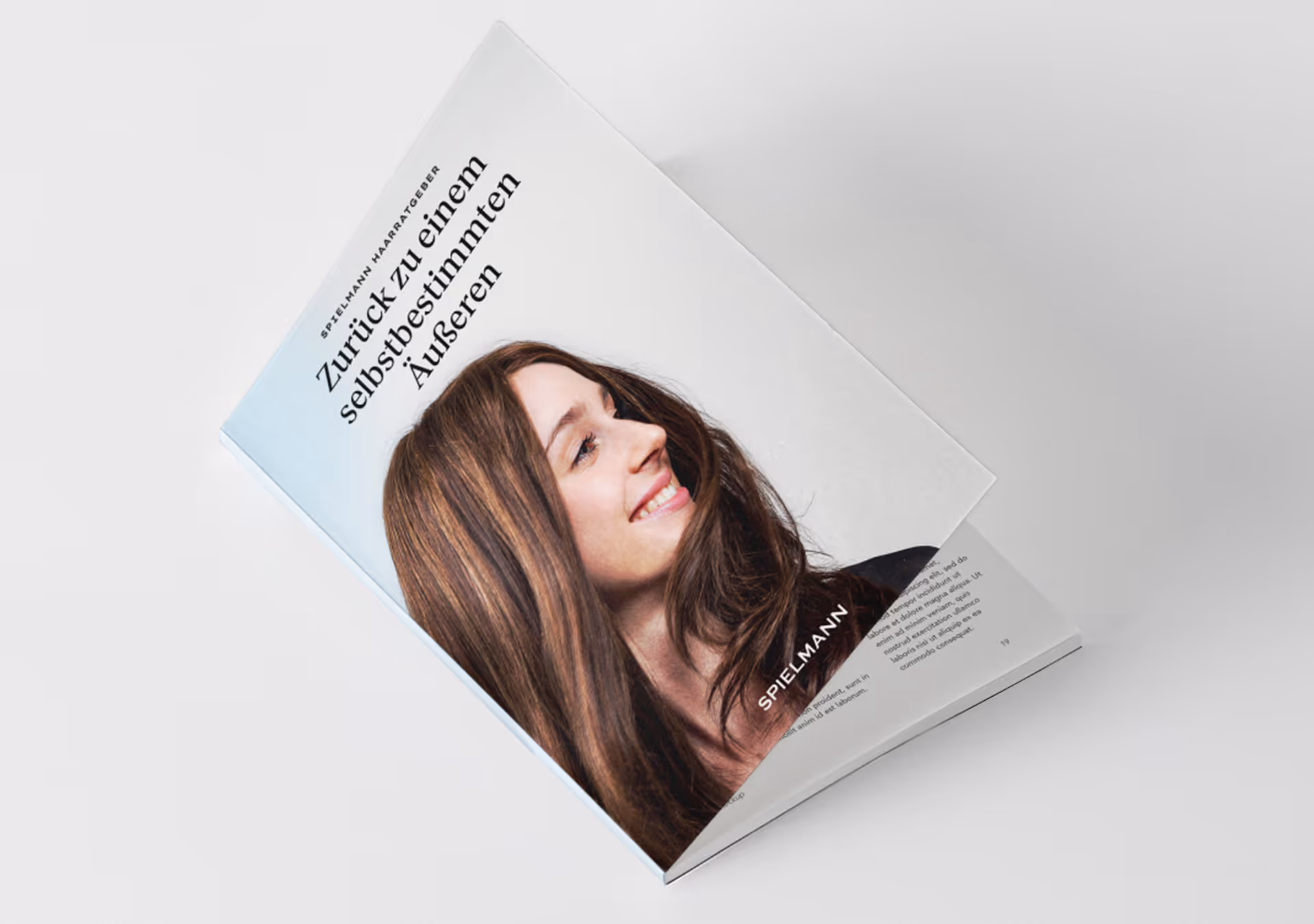 Offene Broschüre mit einem Porträt einer Frau mit langen braunen Haaren, die leicht zur Seite lächelt. Auf der Titelseite steht der Text ‚Zurück zu einem selbstbestimmten Äußeren‘.