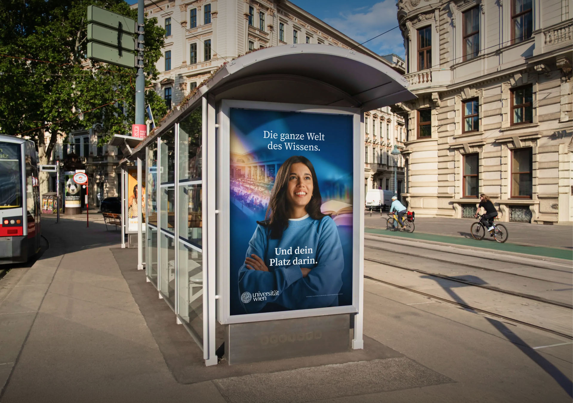 Haltestelle mit Plakat der Universität Wien: "Die ganze Welt des Wissens. Und dein Platz darin."