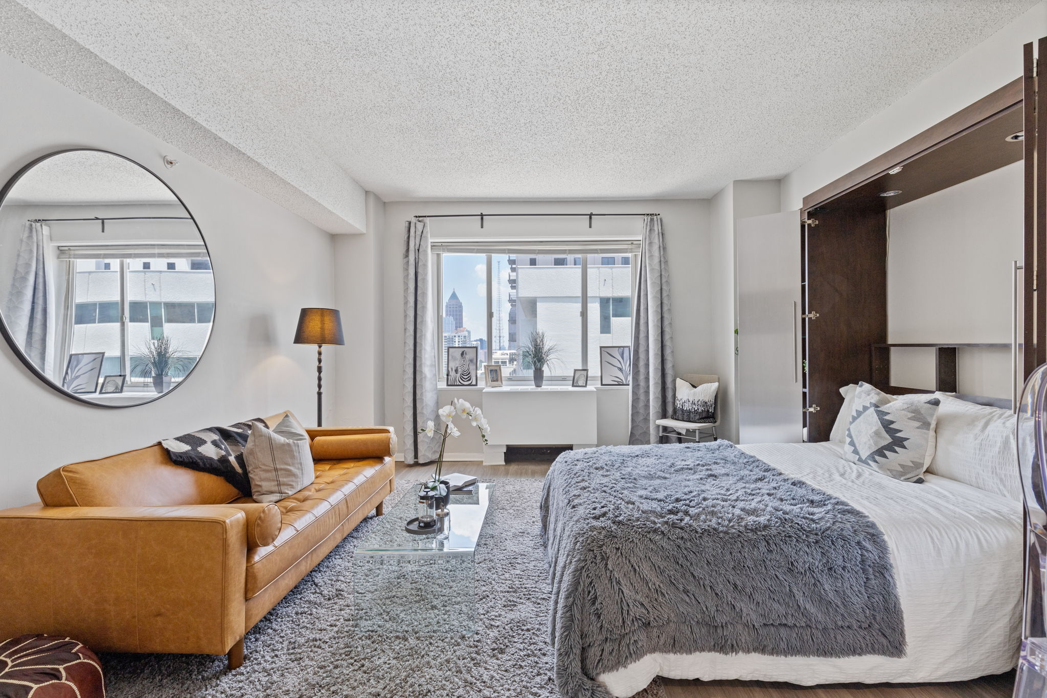 studio apartment with leather couch and bed