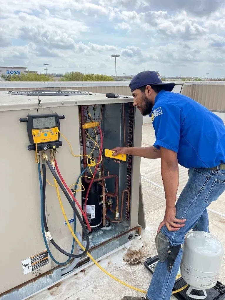 Technician performing seasonal AC maintenance in a residential garden in Austin